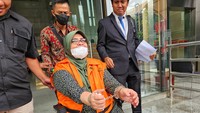 Rahima keluar gedung KPK dengan mengenakan rompi tahanan, tangannya juga diborgol.