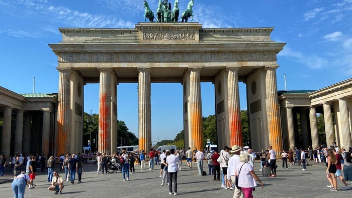 Protes Bahan Bakar Fosil, Gerbang Bersejarah di Jerman Dilumuri Cat People walk in front of the Brandenburg Gate after Last Generation (