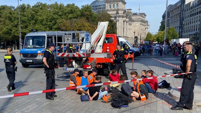 Protes Bahan Bakar Fosil, Gerbang Bersejarah di Jerman Dilumuri Cat People walk in front of the Brandenburg Gate after Last Generation (