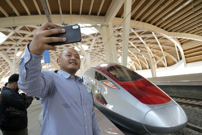 A man takes selfie near a high-speed railway during a test ride ride at Halim station in Jakarta, Indonesia, Monday, Sept. 18, 2023. The Southeast Asias first high-speed railway, a key project under Chinas Belt and Road infrastructure initiative, connects the capital, Jakarta, and Bandung, the heavily populated capital of West Java province and will cut travel time between the two cities from the current three hours to about 40 minutes. (AP Photo/Achmad Ibrahim)