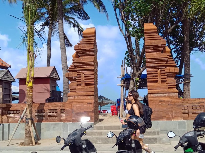 Seorang wisatawan melintas di depan tembok pembatas Pantai Kuta, Badung, Bali, Selasa (19/9/2023).