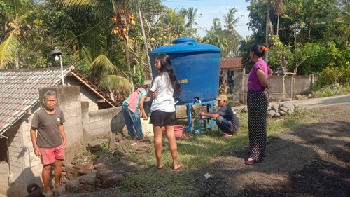 Warga di Banjar Sekar Kejula Kelod, Desa Yehembang Kauh, Kecamatan Mendoyo, Kabupaten Jembrana, Bali, mengambil air bersih di tandon air yang disediakan BPBD Jembrana, Senin (18/9/2023). (Foto: Dok. BPBD Jembrana)