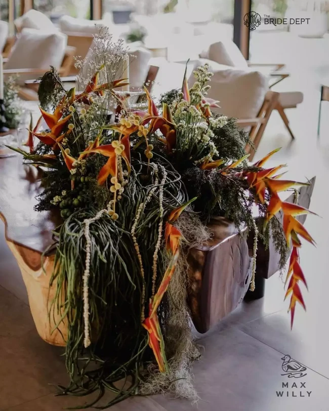 Dilihat dari dekat tampak jelas jika kacang panjang itu dipadukan dengan bunga berwarna oranye dan kuning. Perpaduan beberapa bunga dan kacang panjang tersebut membuat dekorasi menjadi lebih hidup. Foto: Instagram/@thebridedept