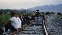 Para migran menunggu di sepanjang jalur kereta api dengan harapan dapat menaiki kereta barang menuju utara di Huehuetoca, Meksiko, Selasa (19/9/2023).  
