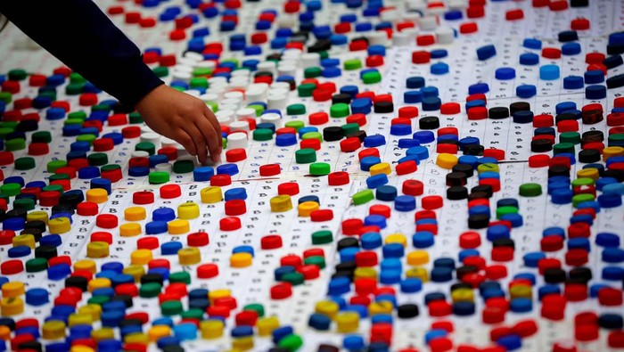 Art teacher Sebastian Ramirez, 41, waves with his students next to the mural they made with plastic bottle caps depicting Argentina's soccer superstar Lionel Messi, nine months after Argentina won the soccer World Cup Qatar 2022, in Grand Bourg, on the outskirts of Buenos Aires, Argentina September 19, 2023. REUTERS/Agustin Marcarian