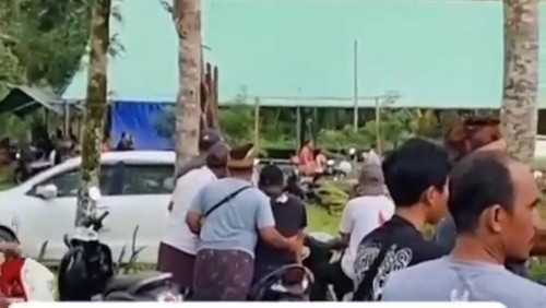 Warga melihat dari jauh saat polisi datang ke arena sabung ayam di Pura Pucak Manik, Desa/Kecamatan Petang, Kabupaten Badung, Selasa (19/9/2023).