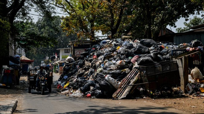 Kendaraan melintas di samping TPS Gudang Selatan, Bandung, Jawa Barat, Rabu (20/9/2023). Pemerintah Provinsi Jawa Barat mencatat, sebanyak 25 ribu ton sampah di Bandung Raya yang meliputi Kota Bandung, Cimahi, Kabupaten Bandung, dan Kabupaten Bandung Barat masih menumpuk di TPS dan sejumlah titik lainnya akibat area utama TPA Sarimukti masih terbakar. ANTARA FOTO/Raisan Al Farisi/hp.