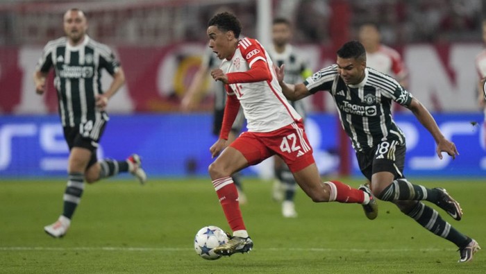 Bayerns Jamal Musiala, centre, is challenged by Manchester Uniteds Casemiro during the Champions League group A soccer match between Bayern Munich and Manchester United at the Allianz Arena stadium in Munich, Germany, Wednesday, Sept. 20, 2023. (AP Photo/Matthias Schrader)