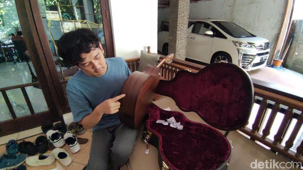 Gitaris Soegi Bornean, Adit Ilyas, menunjukkan gitar kesayangannya yang rusak saat ditemui di Kota Semarang, Kamis (21/9/2023).