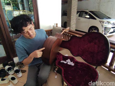 Gitaris Soegi Bornean, Adit Ilyas, menunjukkan gitar kesayangannya yang rusak saat ditemui di Kota Semarang, Kamis (21/9/2023).