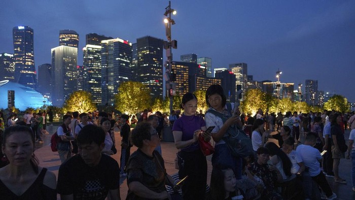 Peoples take picture of Hangzhou Olympic Sports Centre Stadium during light & show performance ahead of the 19th Asian Games along riverside in Hangzhou, China, Tuesday, Sept. 19, 2023. The Asian Games are set to go in China. It's the biggest multi-sport international event in the country since pandemic restrictions were lifted there about nine months ago. (AP Photo/Vincent Thian)