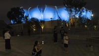 Orang-orang berfoto dengan latar Hangzhou Olympic Sports Centre Stadium. Asian Games ke-19 Hangzhou akan diselenggarakan pada 23 September hingga 8 Oktober 2023. AP/Ng Han Guan
