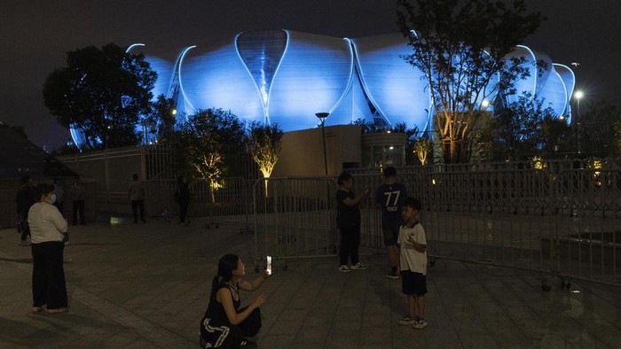 Residents take photos in front of the Hangzhou Olympic Sports Centre Stadium ahead of the 19th Asian Games in Hangzhou, China, Wednesday, Sept. 20, 2023. The Asian Games are set to go in China. It's the biggest multi-sport international event in the country since pandemic restrictions were lifted there about nine months ago. (AP Photo/Ng Han Guan)