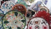 Peserta menata karya seni kriya berupa payung rajut dalam pameran bertajuk Festival Mbois di Gedung Malang Creative Center, Jawa Timur, Kamis (21/9/2023).  