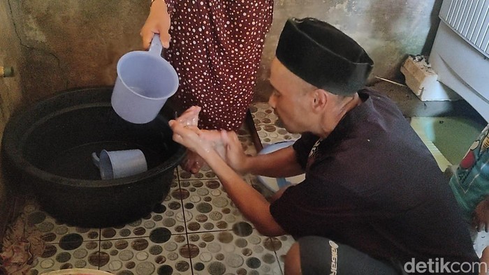 Saepudin salah seorang pengidap Parkinson tengah berwudhu dibantu kepondakannya