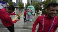 Atlet asal Yaman berfoto dengan maskot Asian Games ke-19 saat upacara penyambutan tim Asian Games ke-19 di Hangzhou. AP/Ng Han Guan  