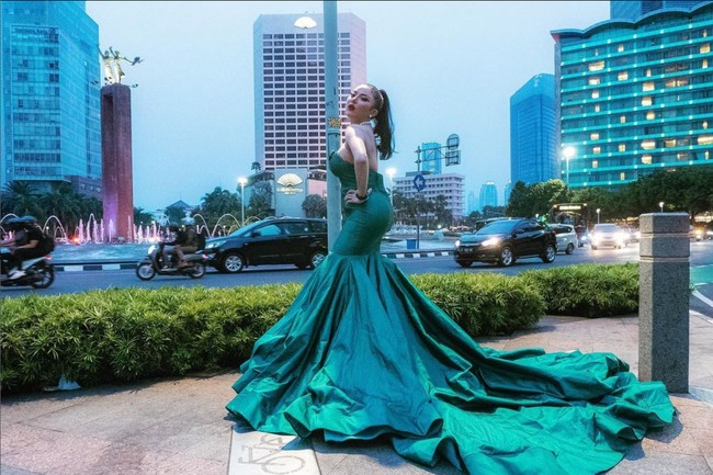 Tampil glamor di jalanan, kenapa tidak? Ayu Aulia pernah berpose di jalan raya mengenakan gaun hijau emerald berpotongan mermaid dengan ekor ruffle yang menyapu aspal. Foto: Instagram/@ayuaulia5252