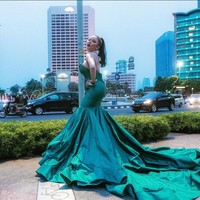 Tampil glamor di jalanan, kenapa tidak? Ayu Aulia pernah berpose di jalan raya mengenakan gaun hijau emerald berpotongan mermaid dengan ekor ruffle yang menyapu aspal. Foto: Instagram/@ayuaulia5252