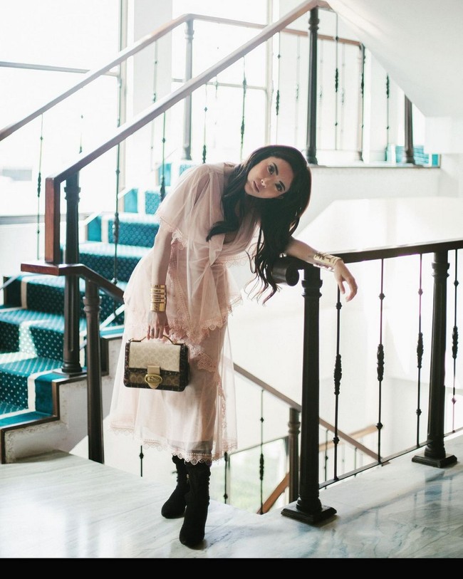 Wanita 29 tahun ini juga pernah menampilkan gaya feminin sekaligus edgy dengan mengenakan gaun transparan dan boots, serta clutch. Foto: Instagram/@ayuaulia5252