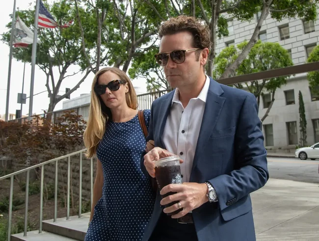 Sejak awal persidangan, Bijou tak pernah absen mendampingi Danny. Tampak Bijou masih menggandeng sang suami dan memberikan dukungan penuh untuk sang suami di tengah tuduhan kasus Danny memperkosa dua wanita pada tahun 2001 dan 2003. Foto: dok. Getty Images