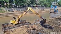 Tampak dua alat berat dikerahkan untuk mengeruk lumpur di Kali Ciliwung, Jumat (22/9).  