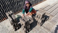 Chusnul Khotimah (60) menata batu bata setelah dijemur di Desa Mayangan, Jombang, Jawa Timur, Kamis (21/9/2023).