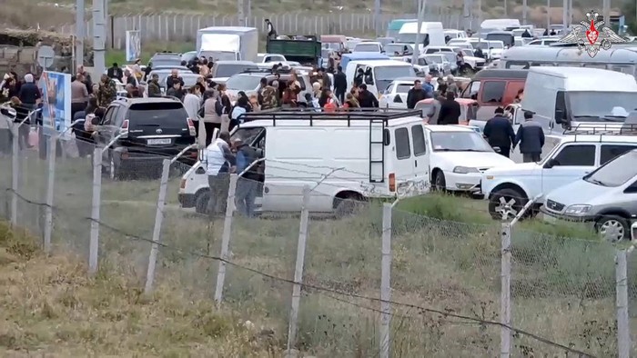 In this photo taken from video released by Russian Defense Ministry Press Service on Thursday, Sept. 21, 2023, Ethnic Armenians gather in a Russian peacekeepers' camp near Stepanakert in Nagorno-Karabakh. Thousands of Nagorno-Karabakh residents flocked to a camp operated by Russian peacekeepers to avoid the fighting, while many others gathered at the airport of the regional capital, Stepanakert, hoping to flee the region. (Russian Defense Ministry Press Service via AP)