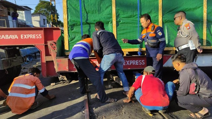 Proses evakuasi truk yang tersangkut di perlintasan sebidang Jalan Industri Barat, Kota Malang