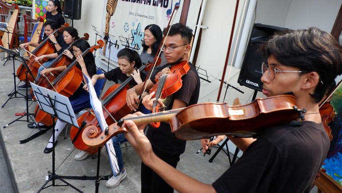 Anggota Light Ministry Orchestra (LMO) bersama para siswa Sekolah Daya Pelita Kasih (DPK) pada acara pelayanan serta pengenalan jenis-jenis alat musik di Sekolah Daya Pelita Kasih (DPK), Pasar Minggu, Jakarta, Sabtu (23/9/2023).