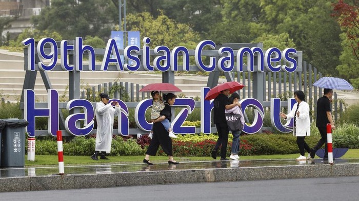 People walk near the Hangzhou Olympic Sports Centre Stadium before the 19th Asian Games start in Hangzhou, China, Saturday, Sept. 23, 2023. (Takumi Sato/Kyodo News via AP)