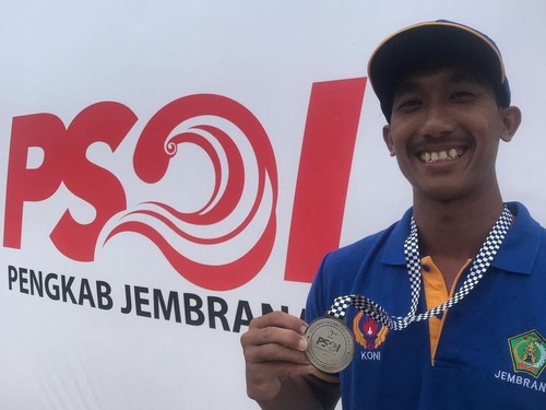 Atlet selancar ombak asal Jembrana, Zaenal Abidin saat menerima medali perak pada ajang Porprov Bali 2022. Namun, dicoret untuk berlaga di PON Aceh-Sumut.