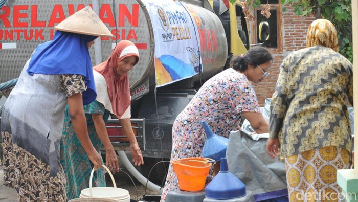 Warga Pati mengambil bantuan air bersih.