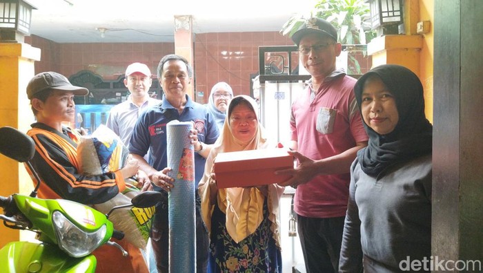 Nenek Sarmini (60) yang rumahnya terbakar di Rawamangun, Jaktim untuk sementara waktu mengungsi di rumah tetangganya. Dia ditemani cucunya. (Kurniawan Fadilah/detikcom)