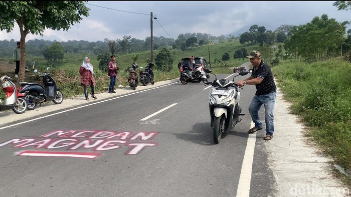 Warga menjajal bukit magnet di Kutalimbaru, Deli Serdang. (Kartika Sari/detikSumut)