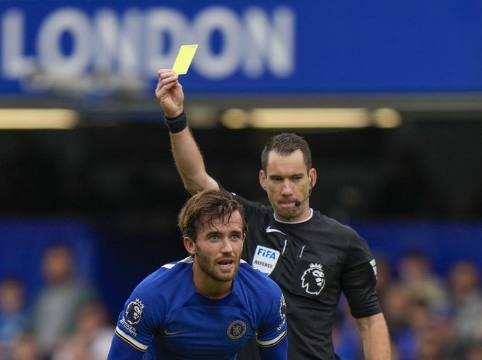 Referee Jarred Gillett shows a yellow card to Chelsea's Ben Chilwell during the English Premier League soccer match between Chelsea and Aston Villa at Stamford Bridge stadium in London, Sunday, Sept. 24, 2023. (AP Photo/Alastair Grant)