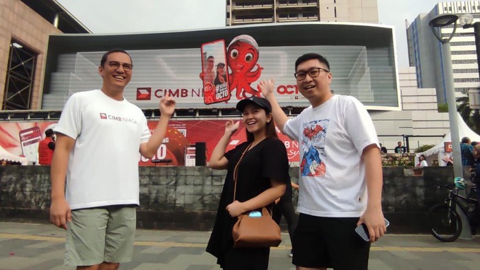 Head of Marketing, Brand & Customer Experience CIMB Niaga Toni Darusman (kiri) bersama nasabah pada acara #SeruBarengOCTO di area Car Free Day (CFD) Jalan Jenderal Sudirman, Jakarta, Minggu (24/9/2023).