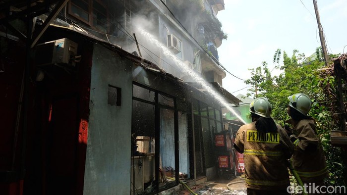 Petugas pemadam kebakaran memadamkan api di Rusun Petamburan, Jakarta. Tampak ruangan yang terbakar adalah tempat laundry pakaian.