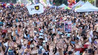 Sejumlah peserta melambaikan tangan saat mengikuti Jalan Gembira Bersama Anies Baswedan dan Gus Muhaimin. Sebagian dari mereka juga ada yang membawa poster Anies-Cak Imin.