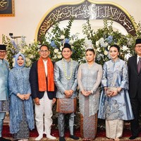 Sang suami mengenakan beskap biru yang dipermanis dengan sulaman. Sentuhan semakin Indonesia dengan pemakaian kain batik yang melapisi celananya. Foto: Instagram Sandiaga Uno (@sandiagauno)