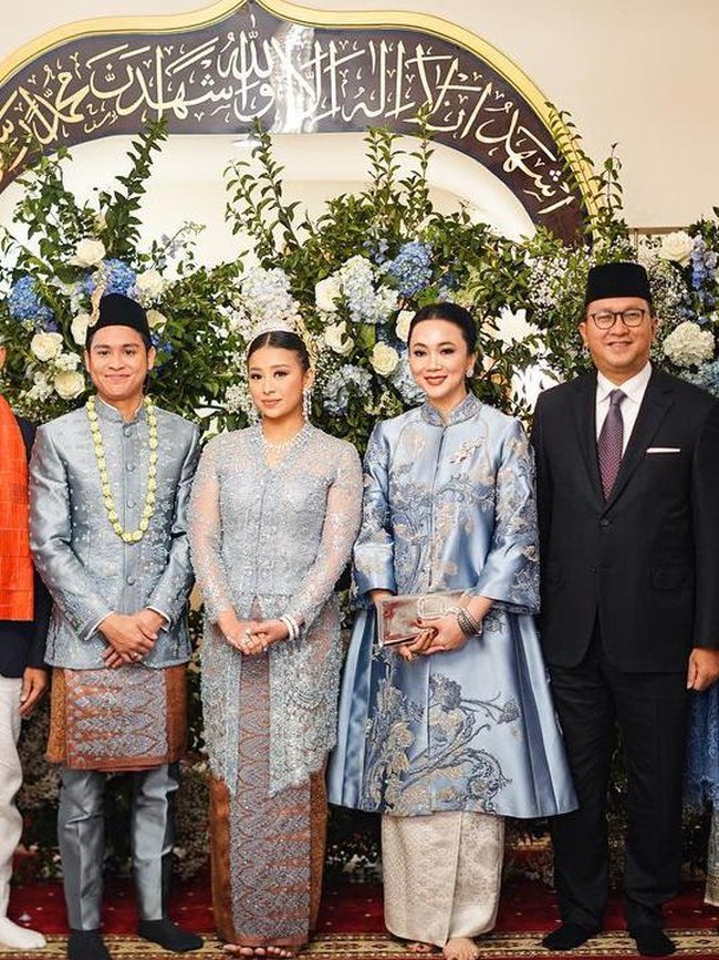 Sang suami mengenakan beskap biru yang dipermanis dengan sulaman. Sentuhan semakin Indonesia dengan pemakaian kain batik yang melapisi celananya. Foto: Instagram Sandiaga Uno (@sandiagauno)