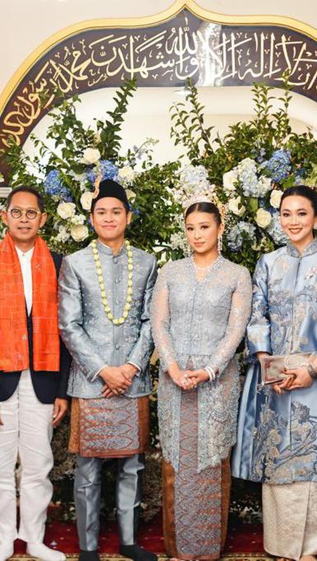 Meski digelar di luar negeri, suasana tetap terasa Indonesia berkat busana kedua mempelai dan keluarga. Atheera sebagai pengantin wanita berbalut kebaya biru panjang penuh brokat dengan padanan batik yang bagian depannya dihiasi detail berkilauan. (Foto: Instagram/@sandiuno)