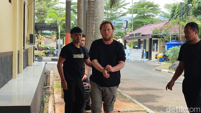 Bule asal Amerika Serikat Arthur Leigh Welohr tersangka pembunuhan kepada mertuanya sendiri di Banjar, Jawa Barat, saat dibawa polisi.