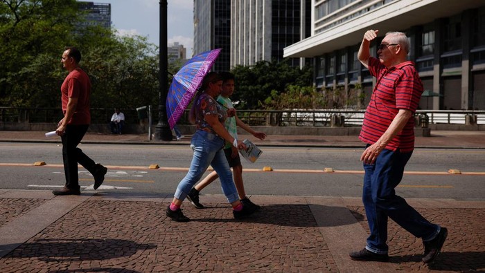 People protect themselves from the sun, during a heatwave in the centre of Sao Paulo, Brazil September 22, 2023. REUTERS/Amanda Perobelli