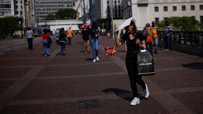 People protect themselves from the sun, during a heatwave in the centre of Sao Paulo, Brazil September 22, 2023. REUTERS/Amanda Perobelli