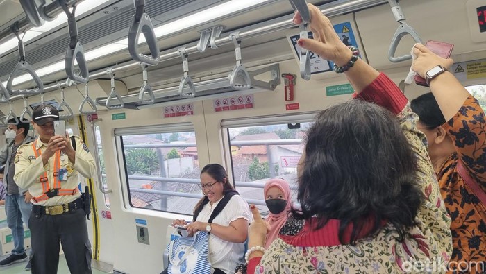 Ibu-ibu menikmati suasana di LRT.
