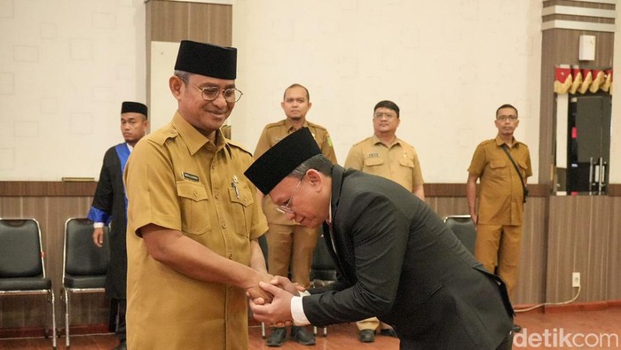 Laksamana Putra Siregar (pakai jas) saat menyalam Sekda Medan Wirya Al Rahman usai dilantik menjadi Kadis Arsip dan Perpustakaan. (Foto: Dok. Pemkot Medan)