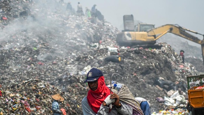 Masih Terbakar, Begini Kondisi TPA Jatiwaringin Tangerang Sejumlah pemulung mencari sampah bernilai jual di antara kepulan asap akibat kemunculan titik api di Tempat Pembuangan Akhir (TPA) Jatiwaringin, Tangerang, Banten, Senin (25/9/2023). Sejumlah titik api masih muncul pascakebakaran TPA Jatiwaringin yang terjadi sejak pertengahan Agustus lalu, dan diduga karena gas metana terbakar akibat suhu panas musim kemarau. ANTARA FOTO/Sulthony Hasanuddin/Spt.
