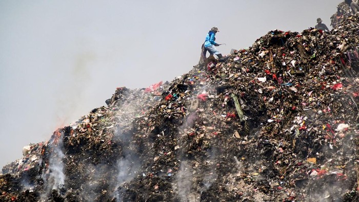 Sejumlah pemulung mencari sampah bernilai jual di antara kepulan asap akibat kemunculan titik api di Tempat Pembuangan Akhir (TPA) Jatiwaringin, Tangerang, Banten, Senin (25/9/2023). Sejumlah titik api masih muncul pascakebakaran TPA Jatiwaringin yang terjadi sejak pertengahan Agustus lalu, dan diduga karena gas metana terbakar akibat suhu panas musim kemarau. ANTARA FOTO/Sulthony Hasanuddin/Spt.