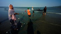 Mereka menjaring ikan saat air laut pasang.