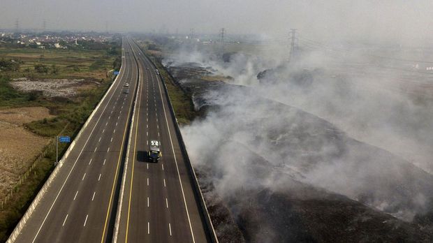 Kebakaran melanda tempat pembuangan sampah (TPS) ilegal di sebelah Jalan Tol Cibitung - Cilincing, Kabupaten Bekasi, Jawa Barat, Minggu (24/9) lalu. Saat ini asap sisa kebakaran masih mengepul di TPS ilegal tersebut.